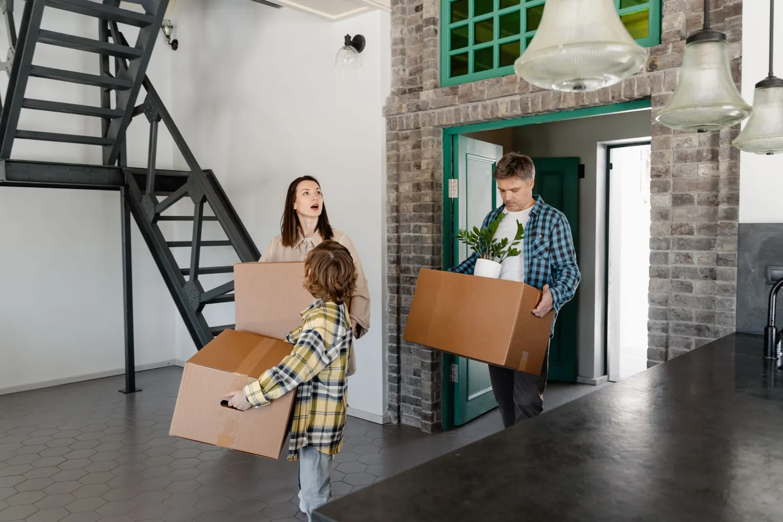 New homeowners carrying a box toward their house