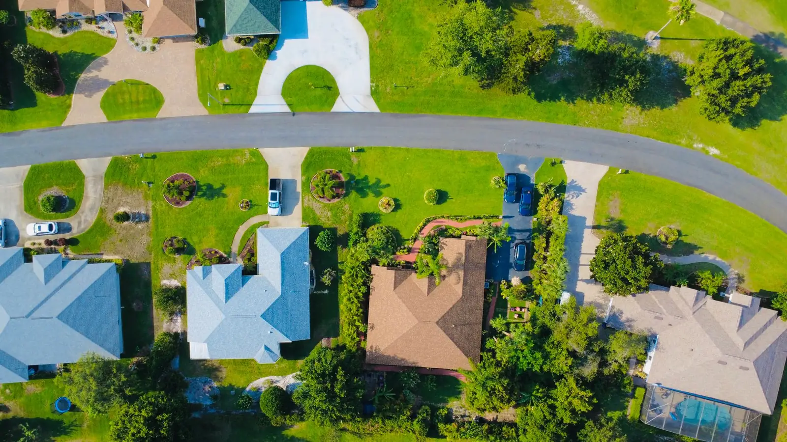 Aerial view of a suburban neighborhood with green lawns
